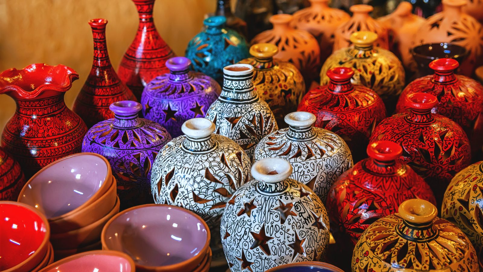 Brightly glazed Avanos pottery — bowls, vases and pierced lamps — displayed for sale