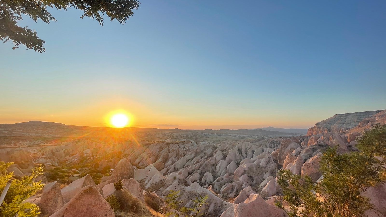 The sun setting over the tuff ridges of the Red and Rose valleys, seen from the rim